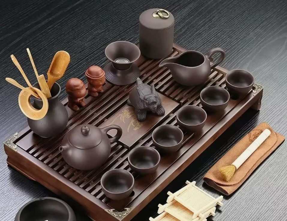Full gongfu tea ceremony set with dark clay teapot, cups, bamboo tools and wooden tray